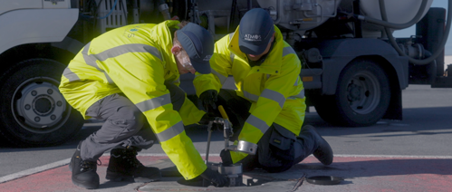 Two engineers using heavy equipment to complete a manual pit valve integrity check