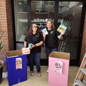 Two Atmos colleagues outside our San Antonio office with boxes of donations for Latched Support