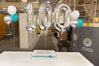 A balloon and cake in Atmos International's UK office to celebrate Atmos' ranking as a top 100 mid-sized company to work for in the UK in 2023