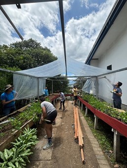 Image of Atmos' Costa Rica colleagues gardening outdoors. The weather is overcast