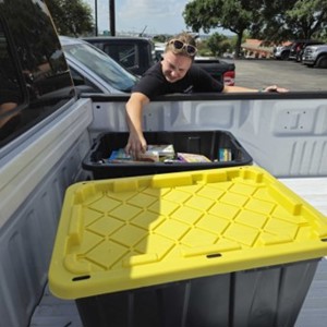 An Atmos colleague retrieving our donations to Latched Support from the back of a pickup truck