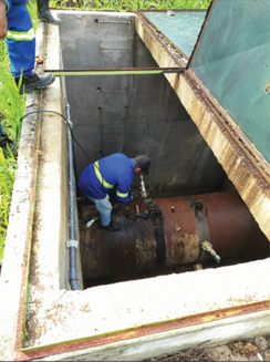 Image of an employee at a Latin American water company helping install leak detection instrumentation