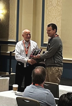 Chief Simulation Scientist Jason Modisette accepting his award for best paper from PSIG