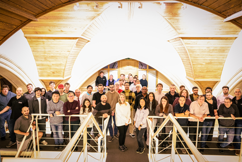 Atmos UK colleagues stood on a walkway in the UK office in celebration of the Best Companies result