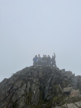 Atmos colleagues celebrating at the summit of one of the three peaks